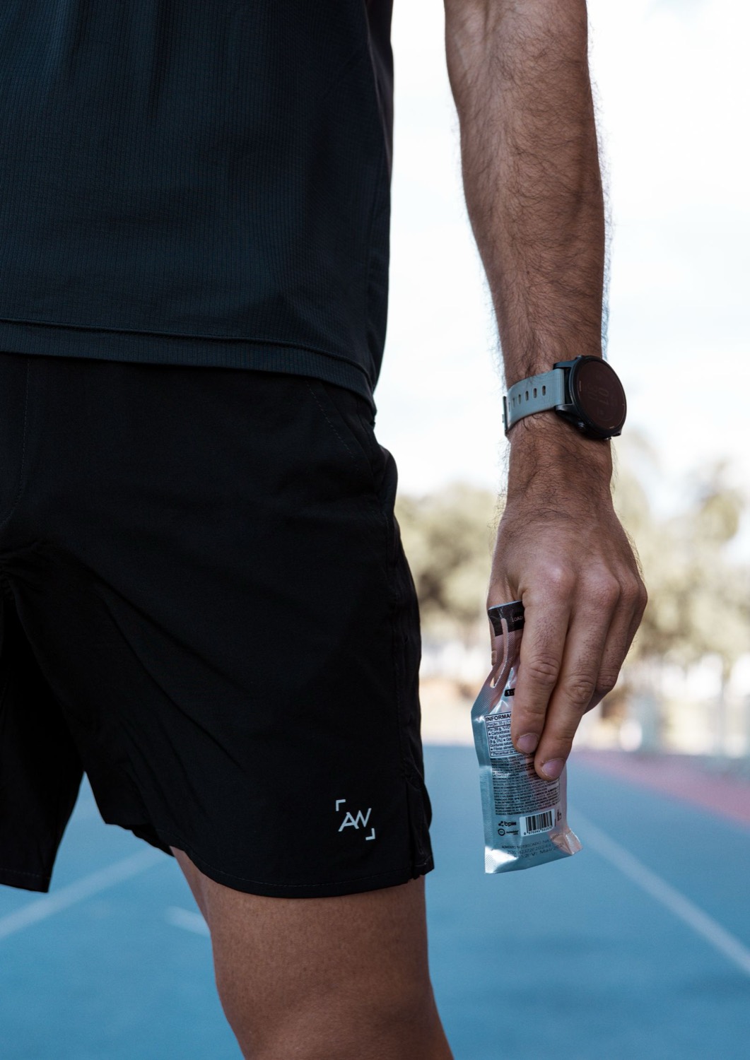A runner holding an energy gel, fueling for a long effort